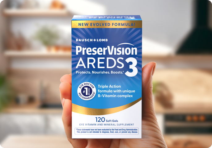 A man in his 60s smiling and holding up a package of PreserVision AREDS 2 Eye Vitamins.